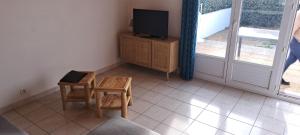 ブルティニョール・シュル・メールにあるMaison a 150 m de la plage de Bretignolles sur merのリビングルーム(テレビ、テーブル、椅子付)