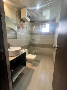 a bathroom with a toilet and a sink at Luxury Haven. Harmony Suites. in Vrindāvan