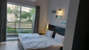 um quarto com uma cama e uma grande janela em Luxury Haven. Harmony Suites. em Vrindavan