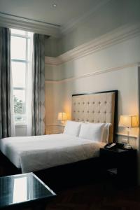 um quarto com uma cama com 2 candeeiros e uma janela em Luxury Haven. Harmony Suites. em Vrindavan