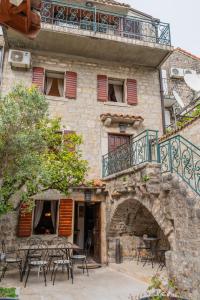 a building with tables and chairs in front of it at Historic Seafront Family Villa in Rafailovici