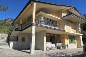 a house with a balcony and a table and chairs at Villa Arianna - Apartments with lake view, pool, garten, privacy, parking, close to city center in Tignale