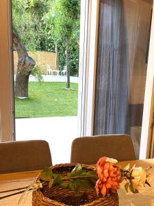 a basket of flowers on a table in front of a window at Apartamento Guadalvivir in Mogón