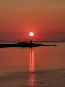 una puesta de sol sobre un cuerpo de agua con la puesta de sol en Horizon View Lodge Bed and Breakfast Glanleam Road Knightstown Valentia Island County Kerry V23 W447 Ireland, en Isla de Valentia