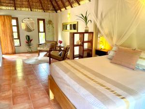a bedroom with a bed and a living room at Hotel Casa Mixteca in Zipolite