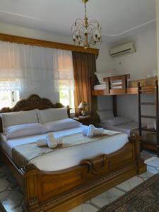 a bedroom with a large wooden bed with white pillows at Yuri Guest House in Gjirokastër