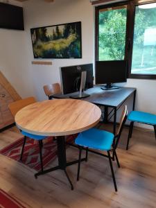 uma mesa e cadeiras com uma secretária com um computador em Stefana's Tiny House Nature Retreat 