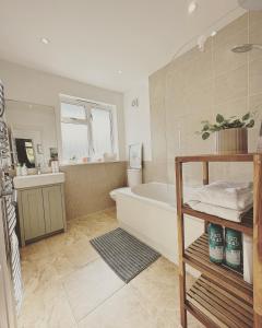 La salle de bains est pourvue d'une baignoire et d'un lavabo. dans l'établissement Urban oasis entire house 3 beds 2 living room expansive garden, à Eltham