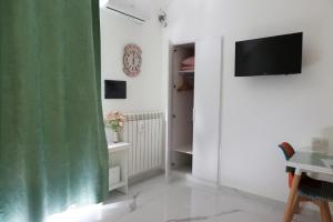 a living room with a television and a green curtain at Sole apartments in Sarno
