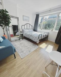 - une chambre avec un lit et un miroir dans l'établissement Urban oasis entire house 3 beds 2 living room expansive garden, à Eltham