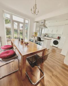 a large kitchen with a wooden table and chairs at Urban oasis entire house 3 beds 2 living room expansive garden in Eltham