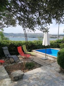 un patio con sillas, una piscina y un árbol en Apartments Villa Julia, en Trogir