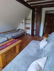 two beds in a room with wooden floors at Podołynia in Dwernik