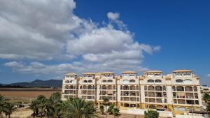 a large building with palm trees in front of it at Estrella in Mar de Cristal