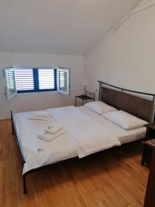 een slaapkamer met een groot bed en handdoeken bij Apartments Villa Julia in Trogir