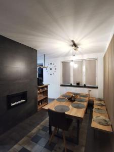 uma sala de jantar com uma mesa e uma lareira em Apartmán Bílá Voda em Cervena Voda