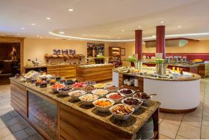 una linea a buffet con molti tipi di cibo diversi di Hotel Hohenwart a Scena