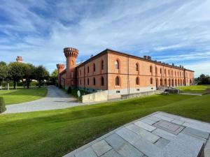 a large brick building with two towers on a grass field at Guest house LangAmore in Bra