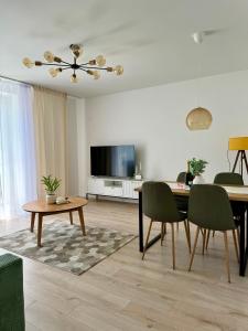 - un salon avec une table et une télévision dans l'établissement Apartment ZOi, à Šamorín