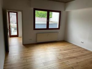Habitación vacía con suelo de madera y 2 ventanas en JustlikeHome - Prime Selection II - Loft, en Bochum
