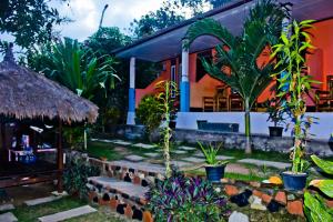 a house with a bunch of plants in front of it at Roy Homestay in Kuta Lombok