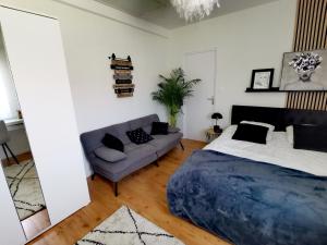 1 dormitorio con 1 cama y 1 sofá en L'atelier de Jane en Sennecey-lès-Dijon