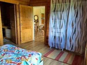 a bedroom with a bed and a door to a room at Cosy bright wooden house in Ariege mountains in Rimont