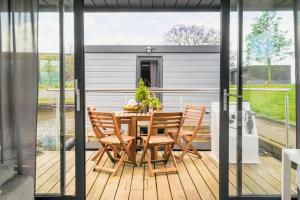 Casa con terraza con mesa y sillas en Cozy Houseboat in Zwartsluis, en Zwartsluis