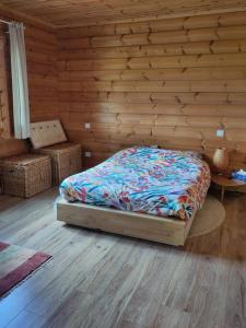 a bedroom with a bed and a wooden wall at Cosy bright wooden house in Ariege mountains in Rimont