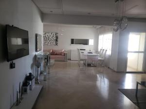 ein Wohnzimmer mit einem Sofa und einem Tisch in der Unterkunft Luxurious apartment in Fès