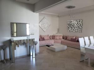 ein Wohnzimmer mit einem rosa Sofa und einem Spiegel in der Unterkunft Luxurious apartment in Fès
