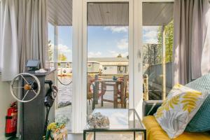 a screened in porch with a view of a house at Charming and cozy Houseboat near Giethoorn in Zwartsluis