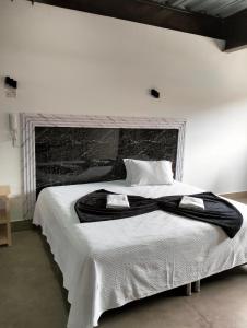1 dormitorio con 1 cama blanca grande y chimenea en Hotel El Cordobes, en Marinilla