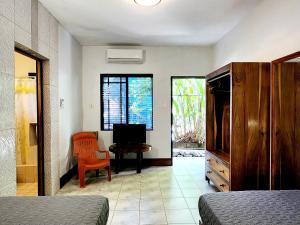 a bedroom with a bed and a desk and a television at Sunrise Club Hotel in Negril