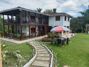 ein Haus mit einem Regenschirm und einem Rasenplatz in der Unterkunft Alojamiento rural la pradera in Montenegro