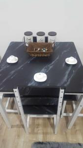 a black table with plates and a basket on top at Condotel at Mesavirre Bacolod City in Bacolod