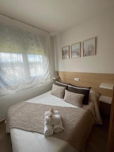 una camera da letto con un grande letto con asciugamani di Apartamento El Viaducto en Redondela a Redondela