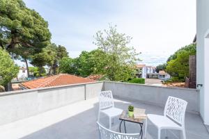 a patio with two chairs and a table on a balcony at Laco Rooms in Novigrad Istria