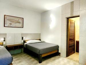 Dormitorio pequeño con cama y espejo en Sunrise Club Hotel, en Negril