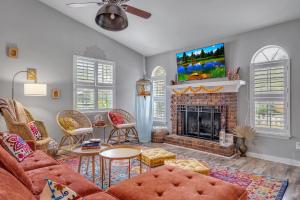 a living room with a fireplace and a tv at Boho Indian Oasis: 3bd - Pool - Tranquil Retreat in Tallahassee