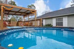 a swimming pool with a pergola and a house at Boho Indian Oasis: 3bd - Pool - Tranquil Retreat in Tallahassee