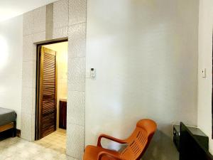 een oranje stoel in een kamer met een slaapkamer bij Sunrise Club Hotel in Negril