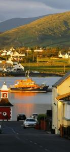 un gran bote naranja en el agua cerca de una ciudad en Horizon View Lodge Bed and Breakfast Glanleam Road Knightstown Valentia Island County Kerry V23 W447 Ireland, en Isla de Valentia