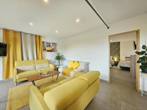 a living room with a yellow couch and a table at Villa lavandin in Apt