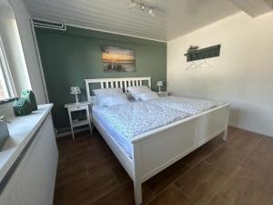 1 dormitorio con cama blanca y almohadas azules en Ferienwohnung Friesenfein en Risum-Lindholm