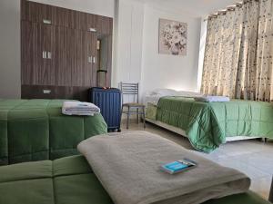 a hotel room with two beds and a suitcase at Hospedaje Las Parraz in Ica