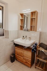 y baño con lavabo y espejo. en Ferienwohnung/Arbeiterwohnung Kampenwand en Rohrdorf