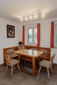 a dining room with a wooden table and chairs at Ferienwohnung/Arbeiterwohnung Kampenwand in Rohrdorf +14 photos