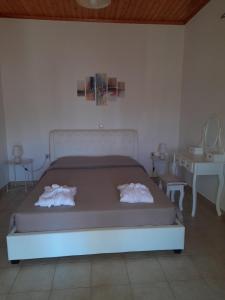 a bedroom with a bed with two towels on it at HeleNik Holiday House in Halikounas
