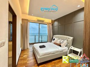 1 dormitorio con cama y ventana grande en Silver Scape Residence Melaka Raya By Heystay Management en Melaka
